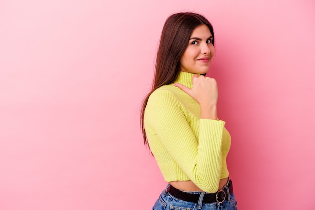 Foto giovane donna caucasica su punti rosa con il dito pollice lontano, ridendo e spensierata.