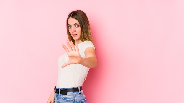 Young caucasian woman on pink wall being shocked