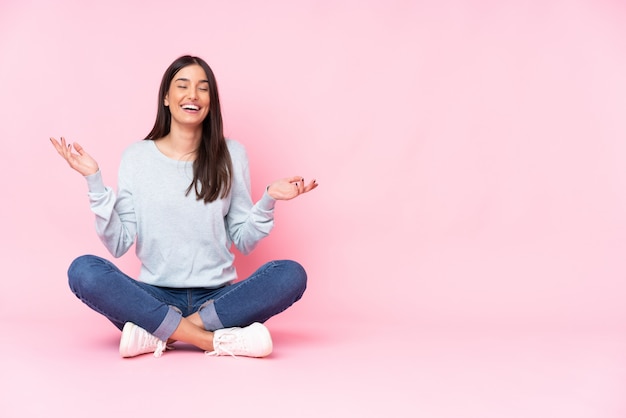 Young caucasian woman on pink wall smiling a lot