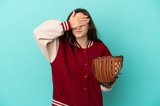 Young caucasian woman playing baseball isolated on blue background covering eyes by hands. Do not want to see something