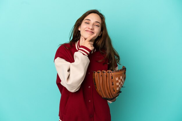 Young caucasian woman playing baseball isolated on blue background happy and smiling