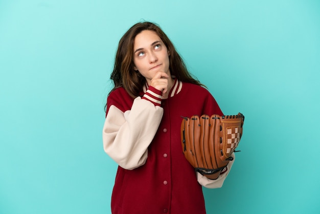 Young caucasian woman playing baseball isolated on blue background and looking up