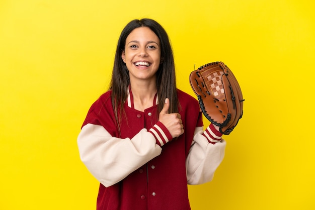 Young caucasian woman playing baseball isolated on yellow background giving a thumbs up gesture