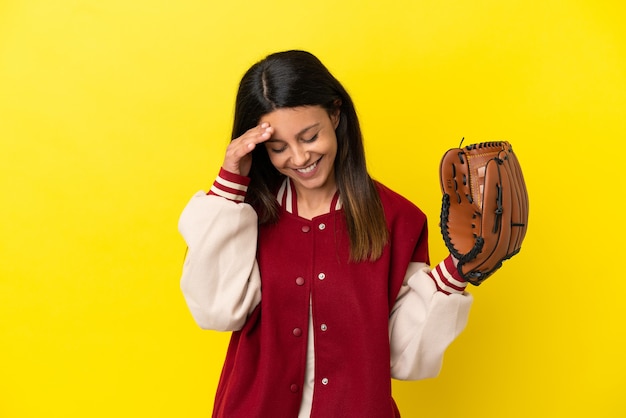 노란색 배경 웃음에 고립 된 야구를 하는 젊은 백인 여자