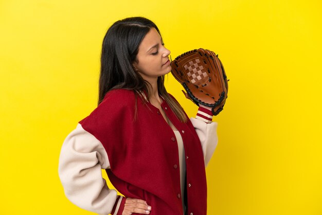 Young caucasian woman playing baseball isolated on yellow background suffering from backache for having made an effort