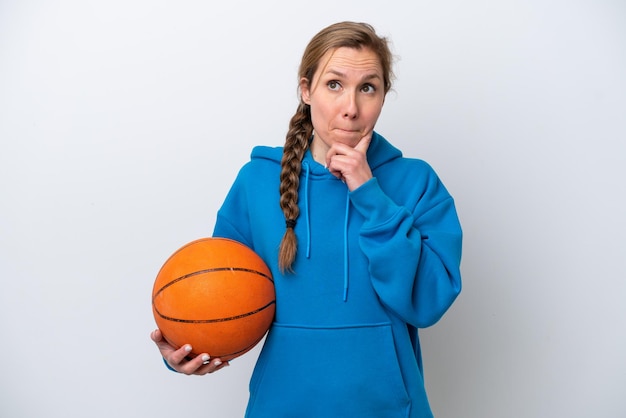 Young caucasian woman playing basketball isolated on white background having doubts and thinking