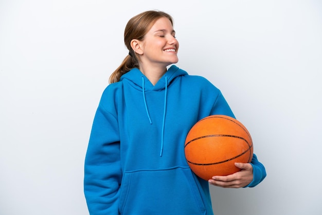 Young caucasian woman playing basketball isolated on white background laughing