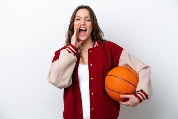 Foto giovane donna caucasica che gioca a basket isolata su sfondo bianco che grida con la bocca spalancata