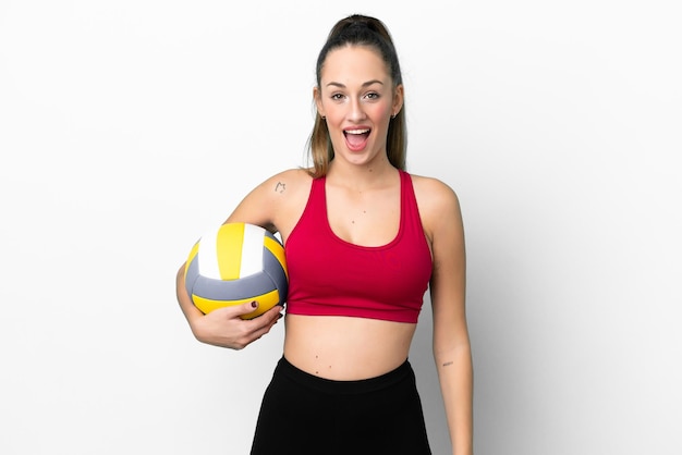 Young caucasian woman playing volleyball isolated on white background with surprise facial expression