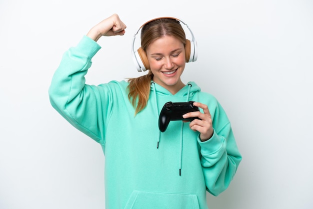 Young caucasian woman playing with a video game controller isolated on white background doing strong gesture