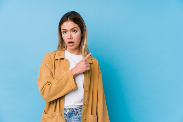 Young caucasian woman pointing to the side