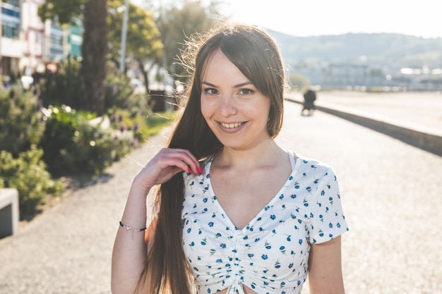 Young caucasian woman portrait on a promenade next to the sea