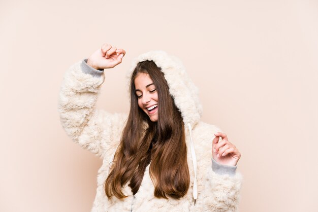 Young caucasian woman posing celebrating a special day, jumps and raise arms with energy.