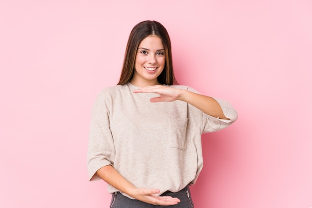 Young caucasian woman posing holding something with both hands