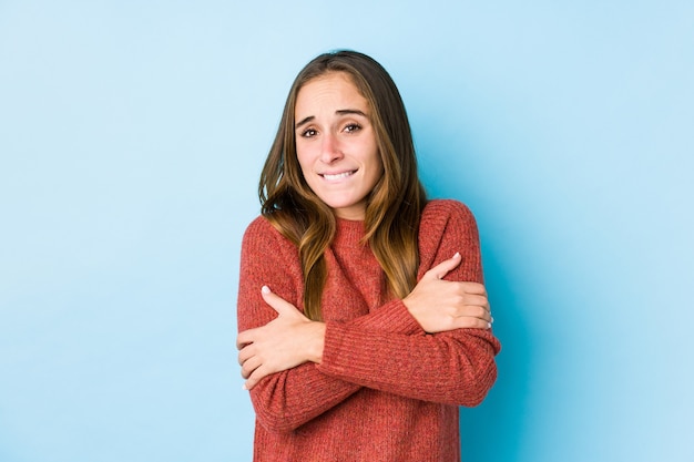 Young caucasian woman posing isolated  going cold due to low temperature or a sickness.