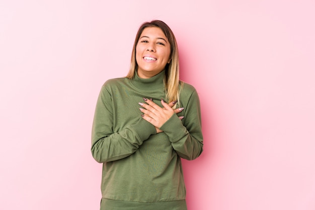 Young caucasian woman posing isolated  has friendly expression, pressing palm to chest. Love concept.