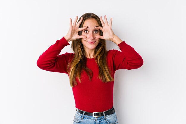 Foto giovane posa caucasica della donna isolata tenendo gli occhi aperti per trovare un'opportunità di successo.