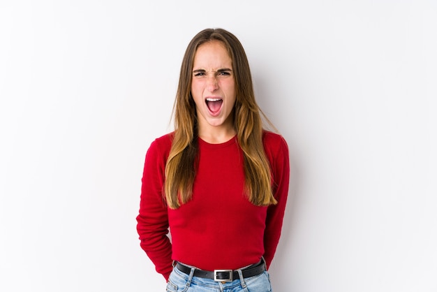 Young caucasian woman posing isolated  screaming very angry and aggressive.