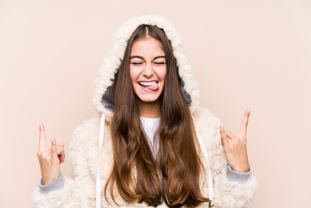 Young caucasian woman posing isolated showing rock gesture with fingers