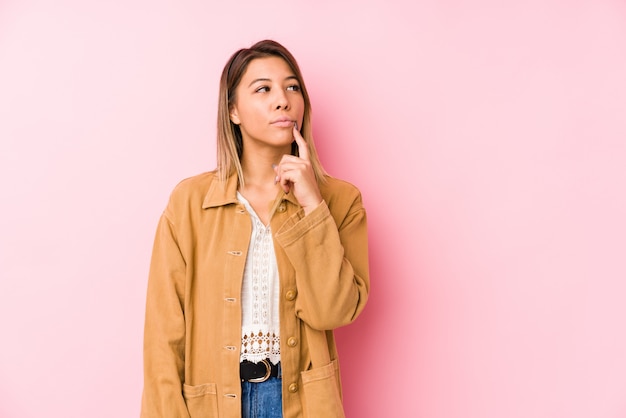 Young caucasian woman posing looking sideways with doubtful and skeptical expression.