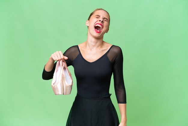 Young caucasian woman practicing ballet over isolated background laughing