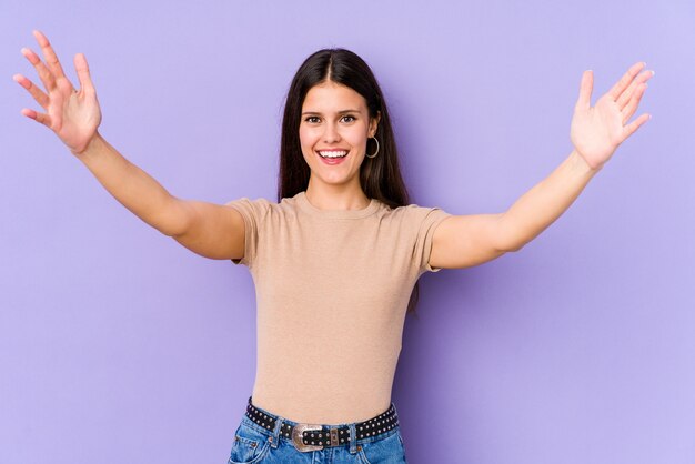 Photo young caucasian woman on purple wall celebrating a victory