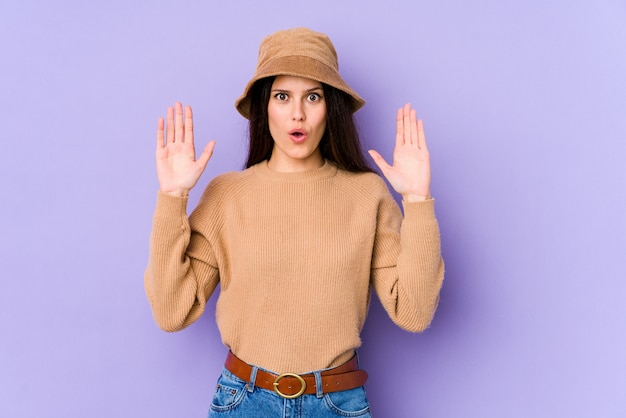 Young caucasian woman on purple wall having an idea