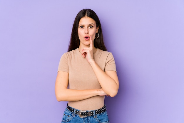 Young caucasian woman on purple wall having some great idea