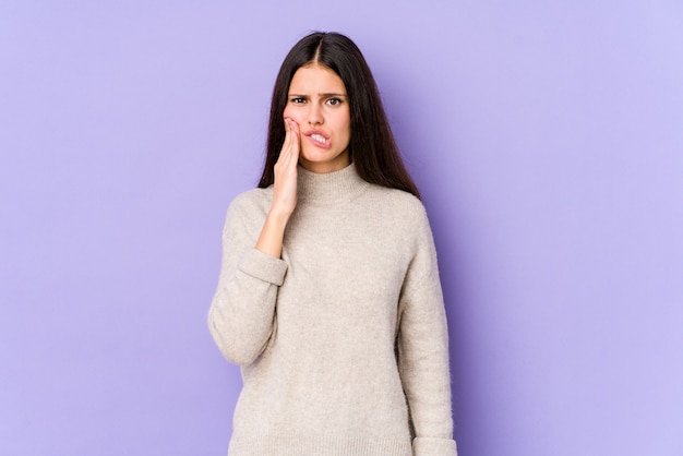 Young caucasian woman on purple wall having a strong teeth pain