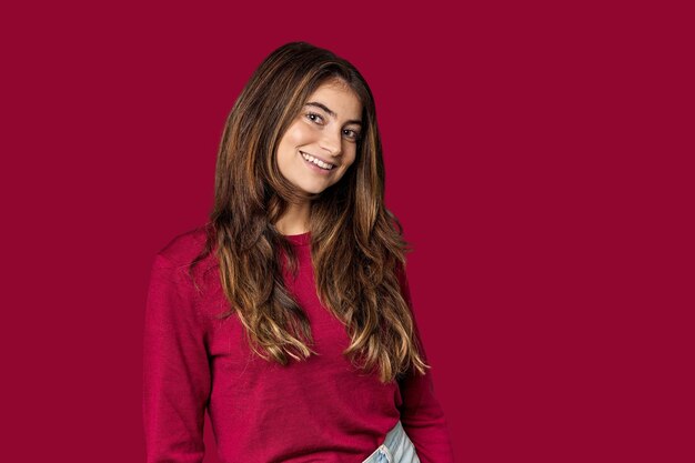 Young Caucasian woman in red sweater in studio