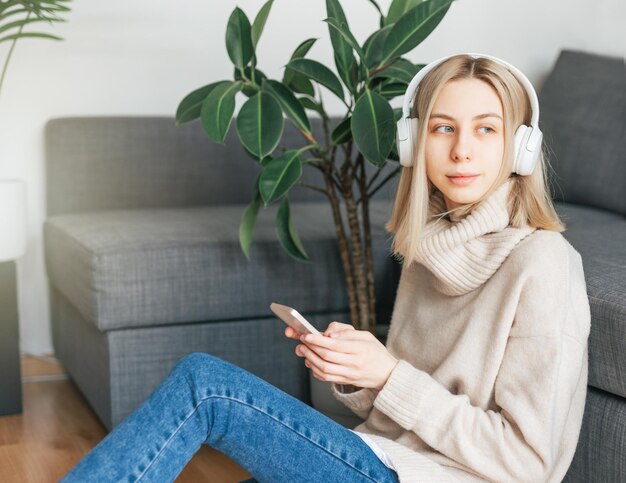 Young caucasian woman relaxes at home with music