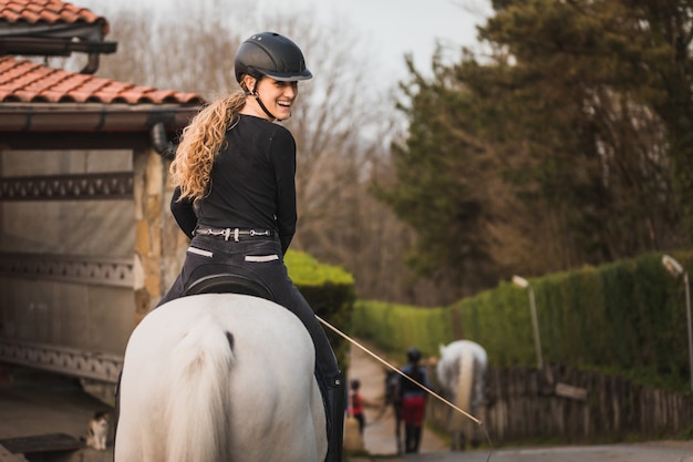 Young caucasian woman riding a horse in a horse centre