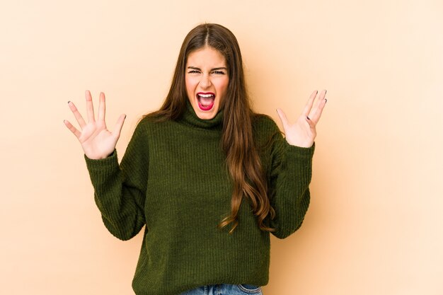 Young caucasian woman screaming to the sky, looking up, frustrated.