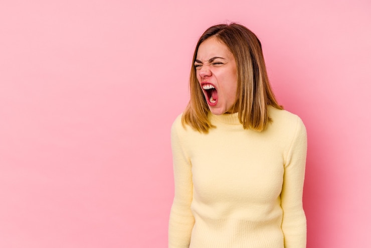 Photo young caucasian woman  shouting very angry, rage concept, frustrated.