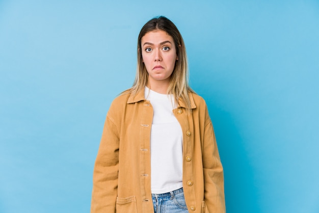 Photo young caucasian woman shrugs shoulders and open eyes confused.