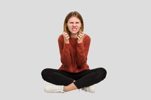 Young caucasian woman sitting on the floor cutout isolated