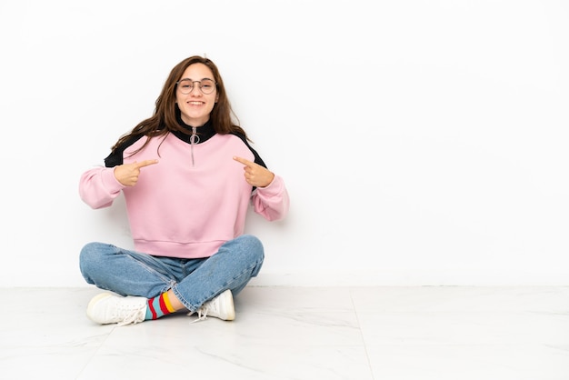 Photo young caucasian woman sitting on the floor isolated on white background with surprise facial expression