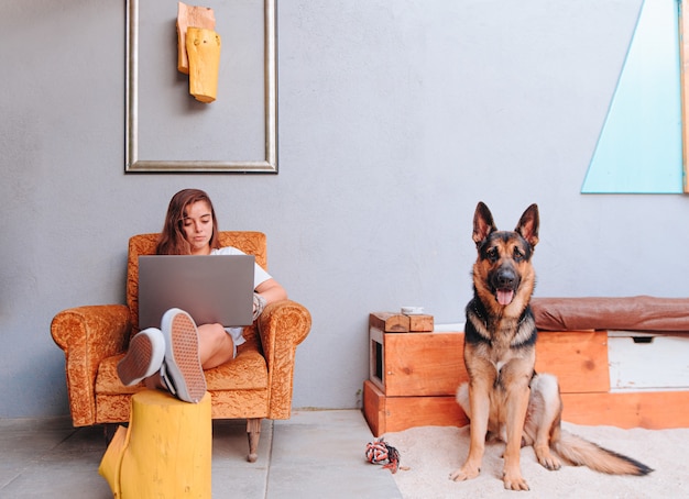 Young Caucasian woman sitting on a sofa while teleworking with the computer