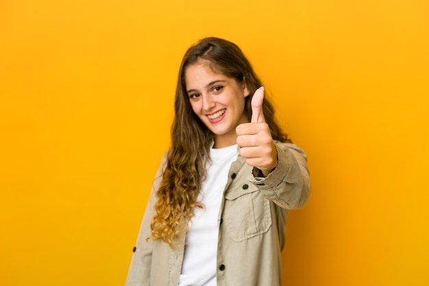 Young caucasian woman smiling and raising thumb up