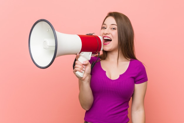 Young caucasian woman speaking through a megaphone