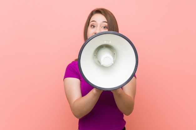 Young caucasian woman speaking through a megaphone