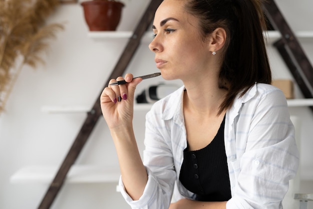 Young caucasian woman student or remote worker sitting at a desk at home in an office