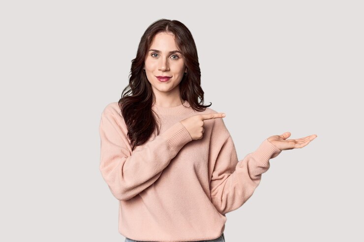 Photo young caucasian woman in a studio setting excited holding a copy space on palm