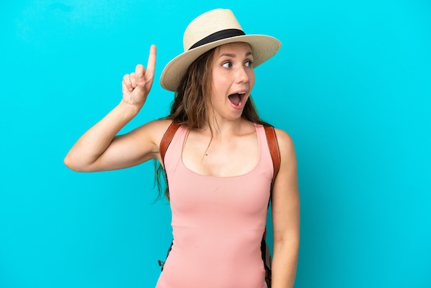 Young caucasian woman in summer holidays isolated on blue background intending to realizes the solution while lifting a finger up