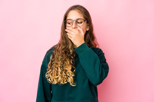 Young caucasian woman thoughtful looking to a copy space covering mouth with hand.