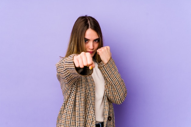 Giovane donna caucasica che lancia un pugno, rabbia, combattimenti a causa di un argomento, boxe.