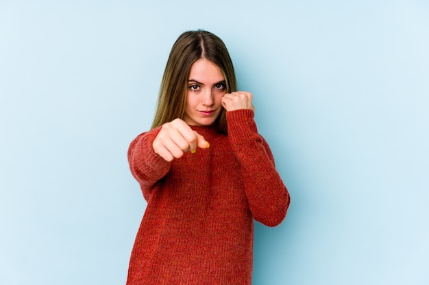 Young caucasian woman throwing a punch, anger, fighting due to an argument, boxing.