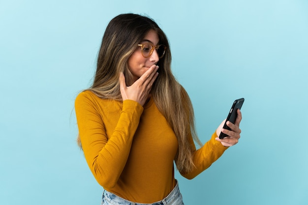 Young caucasian woman using mobile phone isolated