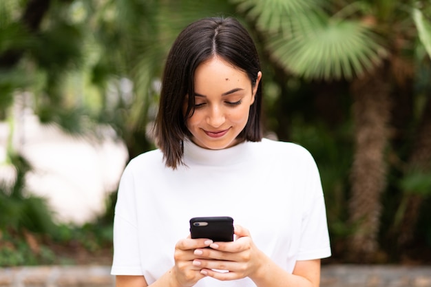 Young caucasian woman using a phone at outdoors