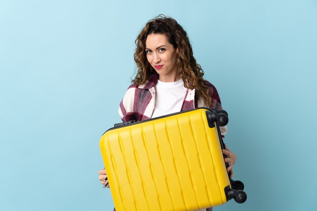 Young caucasian woman in vacation with travel suitcase